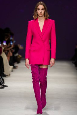 MİLAN, İTALYA - 24 Şubat 2022 'de Milano Moda Haftası / Kış 2023' te İtalya 'nın Milano kentinde düzenlenen Genny defilesinde bir model podyumda yürüyor..