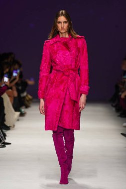 MİLAN, İTALYA - 24 Şubat 2022 'de Milano Moda Haftası / Kış 2023' te İtalya 'nın Milano kentinde düzenlenen Genny defilesinde bir model podyumda yürüyor..