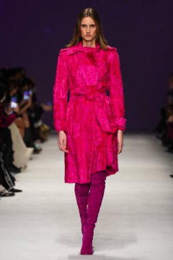 MİLAN, İTALYA - 24 Şubat 2022 'de Milano Moda Haftası / Kış 2023' te İtalya 'nın Milano kentinde düzenlenen Genny defilesinde bir model podyumda yürüyor..