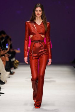 MİLAN, İTALYA - 24 Şubat 2022 'de Milano Moda Haftası / Kış 2023' te İtalya 'nın Milano kentinde düzenlenen Genny defilesinde bir model podyumda yürüyor..