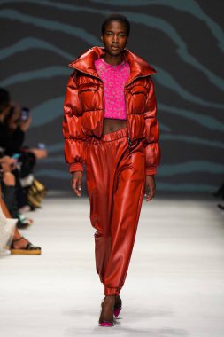 MİLAN, İTALYA - 24 Şubat 2022 'de Milano Moda Haftası / Kış 2023' te İtalya 'nın Milano kentinde düzenlenen Genny defilesinde bir model podyumda yürüyor..