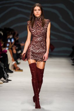 MİLAN, İTALYA - 24 Şubat 2022 'de Milano Moda Haftası / Kış 2023' te İtalya 'nın Milano kentinde düzenlenen Genny defilesinde bir model podyumda yürüyor..