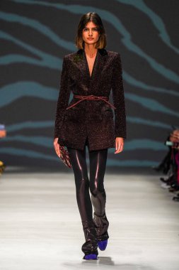 MİLAN, İTALYA - 24 Şubat 2022 'de Milano Moda Haftası / Kış 2023' te İtalya 'nın Milano kentinde düzenlenen Genny defilesinde bir model podyumda yürüyor..
