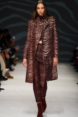 MİLAN, İTALYA - 24 Şubat 2022 'de Milano Moda Haftası / Kış 2023' te İtalya 'nın Milano kentinde düzenlenen Genny defilesinde bir model podyumda yürüyor..