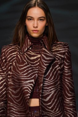 MİLAN, İTALYA - 24 Şubat 2022 'de Milano Moda Haftası / Kış 2023' te İtalya 'nın Milano kentinde düzenlenen Genny defilesinde bir model podyumda yürüyor..