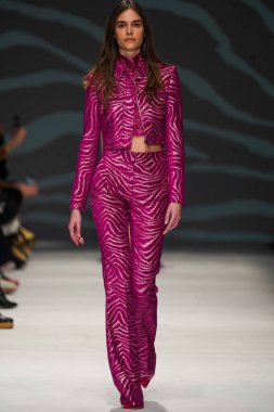 MİLAN, İTALYA - 24 Şubat 2022 'de Milano Moda Haftası / Kış 2023' te İtalya 'nın Milano kentinde düzenlenen Genny defilesinde bir model podyumda yürüyor..