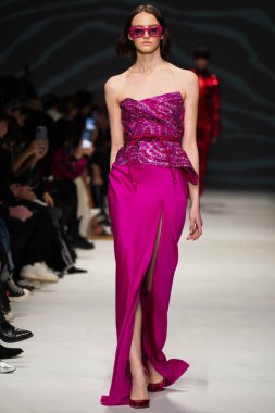 MİLAN, İTALYA - 24 Şubat 2022 'de Milano Moda Haftası / Kış 2023' te İtalya 'nın Milano kentinde düzenlenen Genny defilesinde bir model podyumda yürüyor..