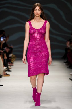 MİLAN, İTALYA - 24 Şubat 2022 'de Milano Moda Haftası / Kış 2023' te İtalya 'nın Milano kentinde düzenlenen Genny defilesinde bir model podyumda yürüyor..