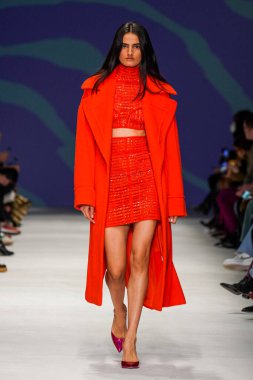 MİLAN, İTALYA - 24 Şubat 2022 'de Milano Moda Haftası / Kış 2023' te İtalya 'nın Milano kentinde düzenlenen Genny defilesinde bir model podyumda yürüyor..