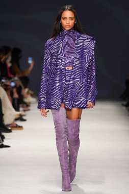 MİLAN, İTALYA - 24 Şubat 2022 'de Milano Moda Haftası / Kış 2023' te İtalya 'nın Milano kentinde düzenlenen Genny defilesinde bir model podyumda yürüyor..