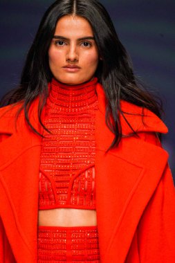 MİLAN, İTALYA - 24 Şubat 2022 'de Milano Moda Haftası / Kış 2023' te İtalya 'nın Milano kentinde düzenlenen Genny defilesinde bir model podyumda yürüyor..