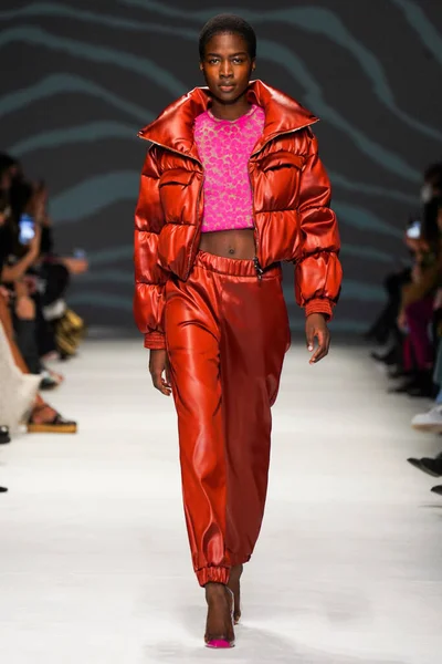 MİLAN, İTALYA - 24 Şubat 2022 'de Milano Moda Haftası / Kış 2023' te İtalya 'nın Milano kentinde düzenlenen Genny defilesinde bir model podyumda yürüyor..