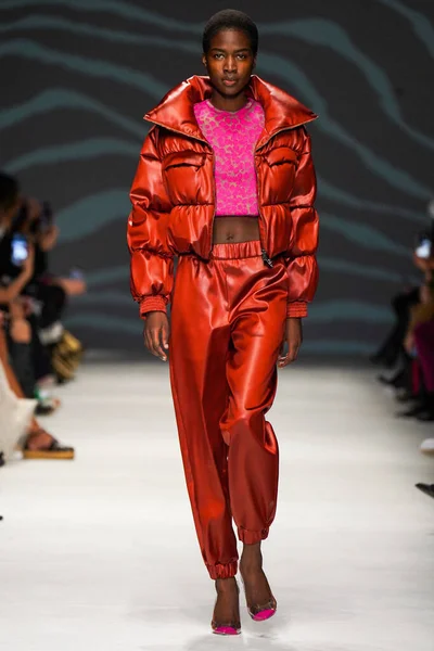 MİLAN, İTALYA - 24 Şubat 2022 'de Milano Moda Haftası / Kış 2023' te İtalya 'nın Milano kentinde düzenlenen Genny defilesinde bir model podyumda yürüyor..