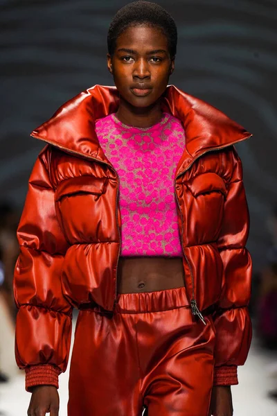 MİLAN, İTALYA - 24 Şubat 2022 'de Milano Moda Haftası / Kış 2023' te İtalya 'nın Milano kentinde düzenlenen Genny defilesinde bir model podyumda yürüyor..