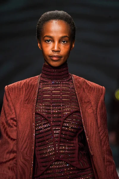 MİLAN, İTALYA - 24 Şubat 2022 'de Milano Moda Haftası / Kış 2023' te İtalya 'nın Milano kentinde düzenlenen Genny defilesinde bir model podyumda yürüyor..