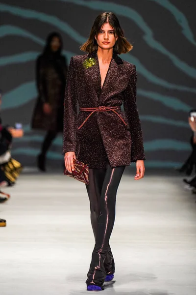 MİLAN, İTALYA - 24 Şubat 2022 'de Milano Moda Haftası / Kış 2023' te İtalya 'nın Milano kentinde düzenlenen Genny defilesinde bir model podyumda yürüyor..
