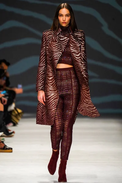 MİLAN, İTALYA - 24 Şubat 2022 'de Milano Moda Haftası / Kış 2023' te İtalya 'nın Milano kentinde düzenlenen Genny defilesinde bir model podyumda yürüyor..