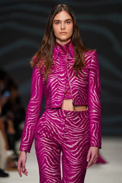 MİLAN, İTALYA - 24 Şubat 2022 'de Milano Moda Haftası / Kış 2023' te İtalya 'nın Milano kentinde düzenlenen Genny defilesinde bir model podyumda yürüyor..