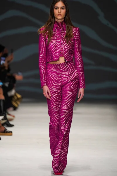 MİLAN, İTALYA - 24 Şubat 2022 'de Milano Moda Haftası / Kış 2023' te İtalya 'nın Milano kentinde düzenlenen Genny defilesinde bir model podyumda yürüyor..