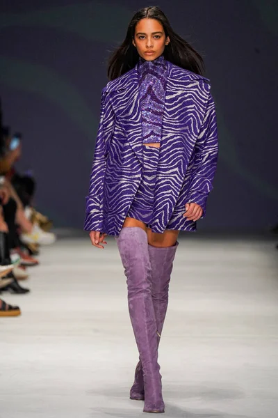 MİLAN, İTALYA - 24 Şubat 2022 'de Milano Moda Haftası / Kış 2023' te İtalya 'nın Milano kentinde düzenlenen Genny defilesinde bir model podyumda yürüyor..