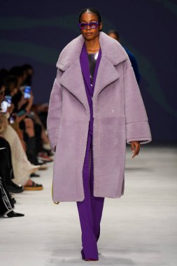 MİLAN, İTALYA - 24 Şubat 2022 'de Milano Moda Haftası / Kış 2023' te İtalya 'nın Milano kentinde düzenlenen Genny defilesinde bir model podyumda yürüyor..