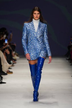 MİLAN, İTALYA - 24 Şubat 2022 'de Milano Moda Haftası / Kış 2023' te İtalya 'nın Milano kentinde düzenlenen Genny defilesinde bir model podyumda yürüyor..