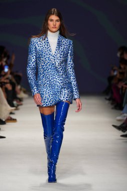 MİLAN, İTALYA - 24 Şubat 2022 'de Milano Moda Haftası / Kış 2023' te İtalya 'nın Milano kentinde düzenlenen Genny defilesinde bir model podyumda yürüyor..