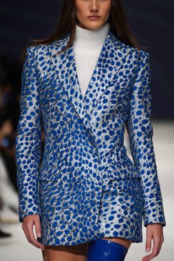 MİLAN, İTALYA - 24 Şubat 2022 'de Milano Moda Haftası / Kış 2023' te İtalya 'nın Milano kentinde düzenlenen Genny defilesinde bir model podyumda yürüyor..