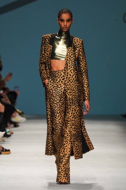 MİLAN, İTALYA - 24 Şubat 2022 'de Milano Moda Haftası / Kış 2023' te İtalya 'nın Milano kentinde düzenlenen Genny defilesinde bir model podyumda yürüyor..