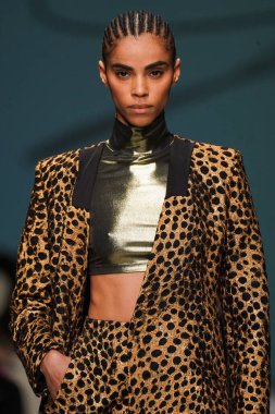 MİLAN, İTALYA - 24 Şubat 2022 'de Milano Moda Haftası / Kış 2023' te İtalya 'nın Milano kentinde düzenlenen Genny defilesinde bir model podyumda yürüyor..