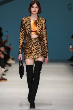 MİLAN, İTALYA - 24 Şubat 2022 'de Milano Moda Haftası / Kış 2023' te İtalya 'nın Milano kentinde düzenlenen Genny defilesinde bir model podyumda yürüyor..