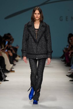 MİLAN, İTALYA - 24 Şubat 2022 'de Milano Moda Haftası / Kış 2023' te İtalya 'nın Milano kentinde düzenlenen Genny defilesinde bir model podyumda yürüyor..