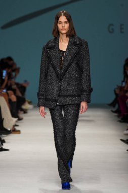MİLAN, İTALYA - 24 Şubat 2022 'de Milano Moda Haftası / Kış 2023' te İtalya 'nın Milano kentinde düzenlenen Genny defilesinde bir model podyumda yürüyor..