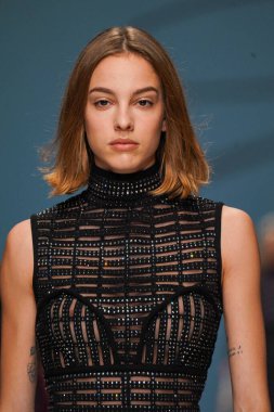 MİLAN, İTALYA - 24 Şubat 2022 'de Milano Moda Haftası / Kış 2023' te İtalya 'nın Milano kentinde düzenlenen Genny defilesinde bir model podyumda yürüyor..