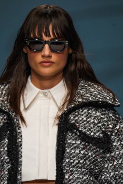 MİLAN, İTALYA - 24 Şubat 2022 'de Milano Moda Haftası / Kış 2023' te İtalya 'nın Milano kentinde düzenlenen Genny defilesinde bir model podyumda yürüyor..