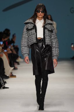 MİLAN, İTALYA - 24 Şubat 2022 'de Milano Moda Haftası / Kış 2023' te İtalya 'nın Milano kentinde düzenlenen Genny defilesinde bir model podyumda yürüyor..