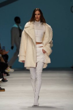 MİLAN, İTALYA - 24 Şubat 2022 'de Milano Moda Haftası / Kış 2023' te İtalya 'nın Milano kentinde düzenlenen Genny defilesinde bir model podyumda yürüyor..