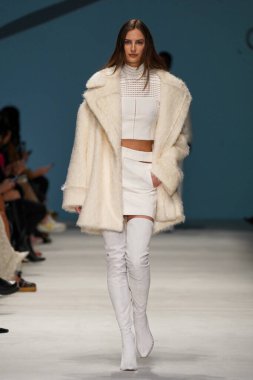 MİLAN, İTALYA - 24 Şubat 2022 'de Milano Moda Haftası / Kış 2023' te İtalya 'nın Milano kentinde düzenlenen Genny defilesinde bir model podyumda yürüyor..