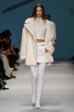 MİLAN, İTALYA - 24 Şubat 2022 'de Milano Moda Haftası / Kış 2023' te İtalya 'nın Milano kentinde düzenlenen Genny defilesinde bir model podyumda yürüyor..