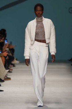 MİLAN, İTALYA - 24 Şubat 2022 'de Milano Moda Haftası / Kış 2023' te İtalya 'nın Milano kentinde düzenlenen Genny defilesinde bir model podyumda yürüyor..