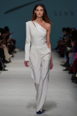 MİLAN, İTALYA - 24 Şubat 2022 'de Milano Moda Haftası / Kış 2023' te İtalya 'nın Milano kentinde düzenlenen Genny defilesinde bir model podyumda yürüyor..