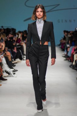MİLAN, İTALYA - 24 Şubat 2022 'de Milano Moda Haftası / Kış 2023' te İtalya 'nın Milano kentinde düzenlenen Genny defilesinde bir model podyumda yürüyor..