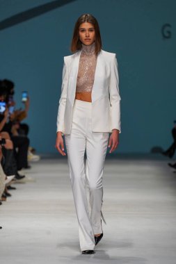 MİLAN, İTALYA - 24 Şubat 2022 'de Milano Moda Haftası / Kış 2023' te İtalya 'nın Milano kentinde düzenlenen Genny defilesinde bir model podyumda yürüyor..