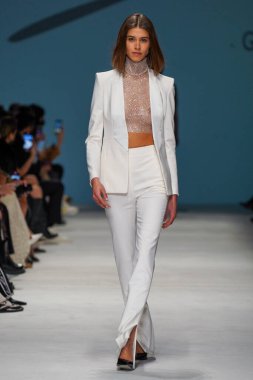 MİLAN, İTALYA - 24 Şubat 2022 'de Milano Moda Haftası / Kış 2023' te İtalya 'nın Milano kentinde düzenlenen Genny defilesinde bir model podyumda yürüyor..