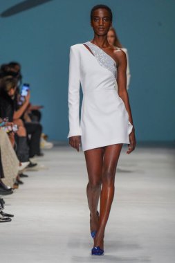 MİLAN, İTALYA - 24 Şubat 2022 'de Milano Moda Haftası / Kış 2023' te İtalya 'nın Milano kentinde düzenlenen Genny defilesinde bir model podyumda yürüyor..