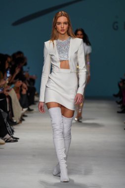 MİLAN, İTALYA - 24 Şubat 2022 'de Milano Moda Haftası / Kış 2023' te İtalya 'nın Milano kentinde düzenlenen Genny defilesinde bir model podyumda yürüyor..