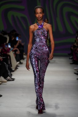 MİLAN, İTALYA - 24 Şubat 2022 'de Milano Moda Haftası / Kış 2023' te İtalya 'nın Milano kentinde düzenlenen Genny defilesinde bir model podyumda yürüyor..