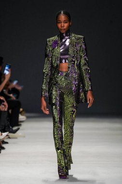 MİLAN, İTALYA - 24 Şubat 2022 'de Milano Moda Haftası / Kış 2023' te İtalya 'nın Milano kentinde düzenlenen Genny defilesinde bir model podyumda yürüyor..