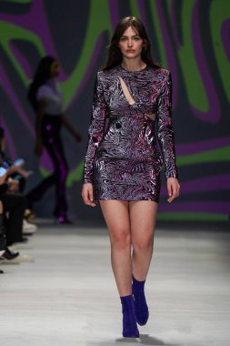 MİLAN, İTALYA - 24 Şubat 2022 'de Milano Moda Haftası / Kış 2023' te İtalya 'nın Milano kentinde düzenlenen Genny defilesinde bir model podyumda yürüyor..