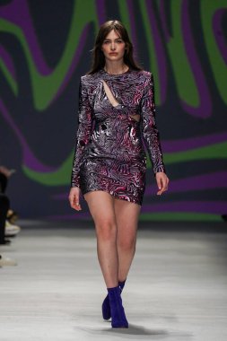 MİLAN, İTALYA - 24 Şubat 2022 'de Milano Moda Haftası / Kış 2023' te İtalya 'nın Milano kentinde düzenlenen Genny defilesinde bir model podyumda yürüyor..